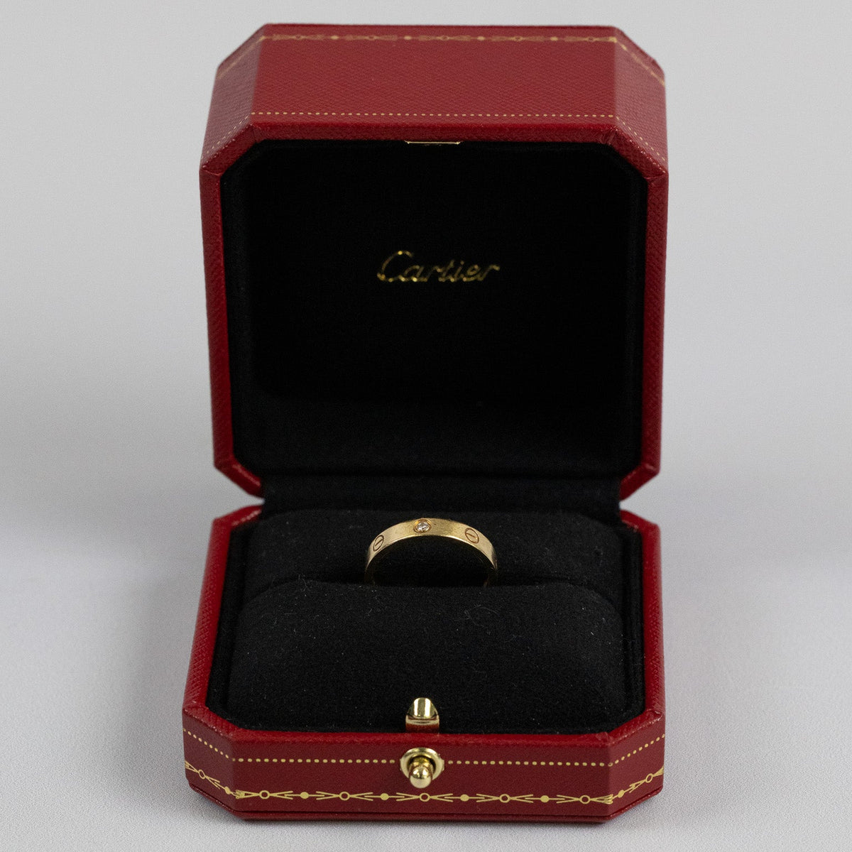 Bague Cartier Love avec diamant présentée dans son écrin Mikaelian