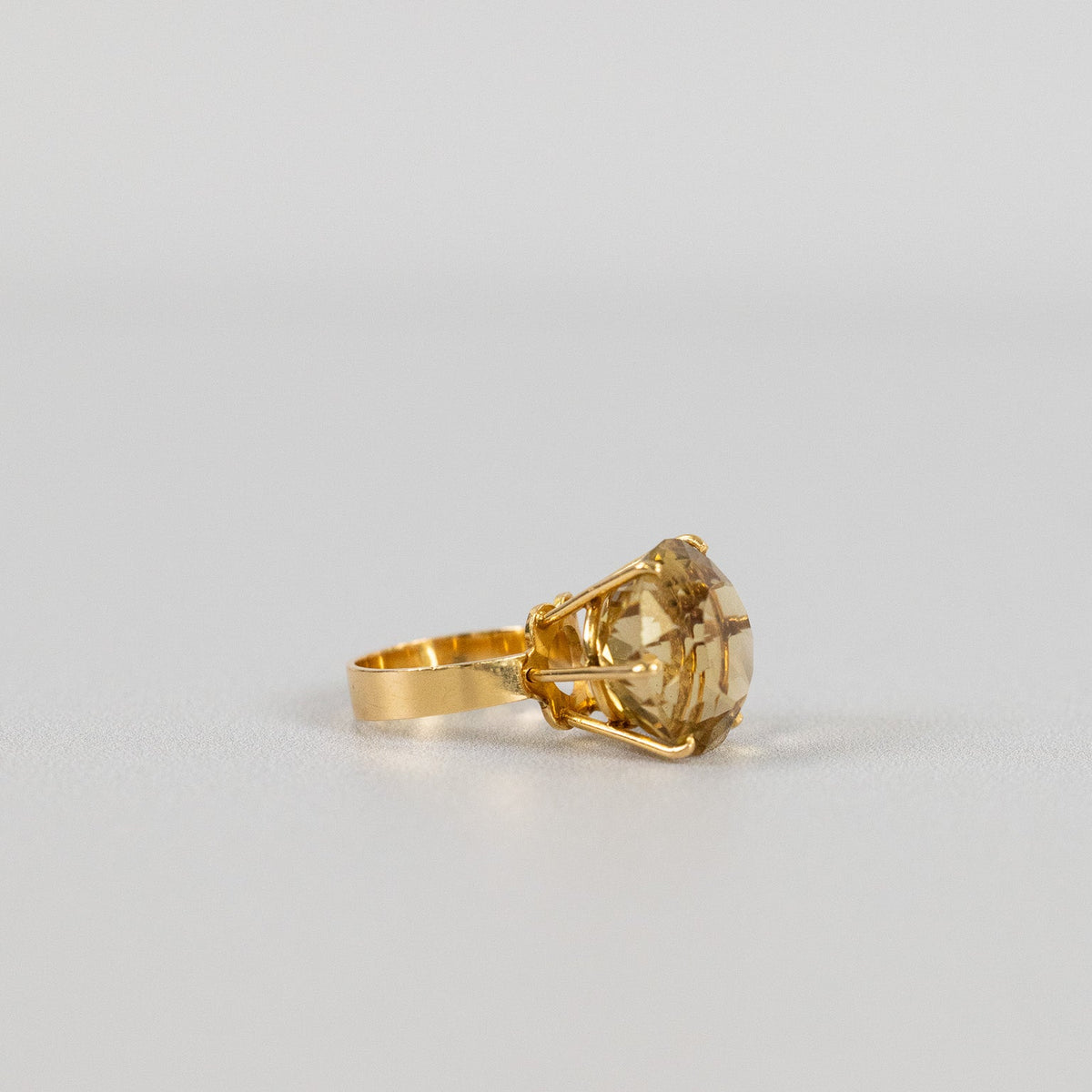 Bague citrine en or jaune 18 carats vue de profil, montrant la hauteur du serti et l’anneau large
