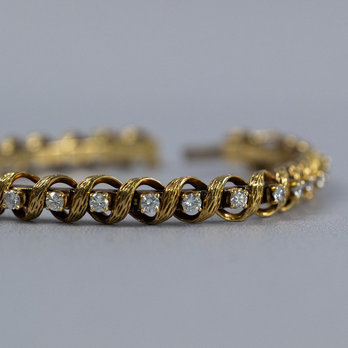 Diamants taille brillant sertis à griffes entre les rubans d’or du bracelet vintage