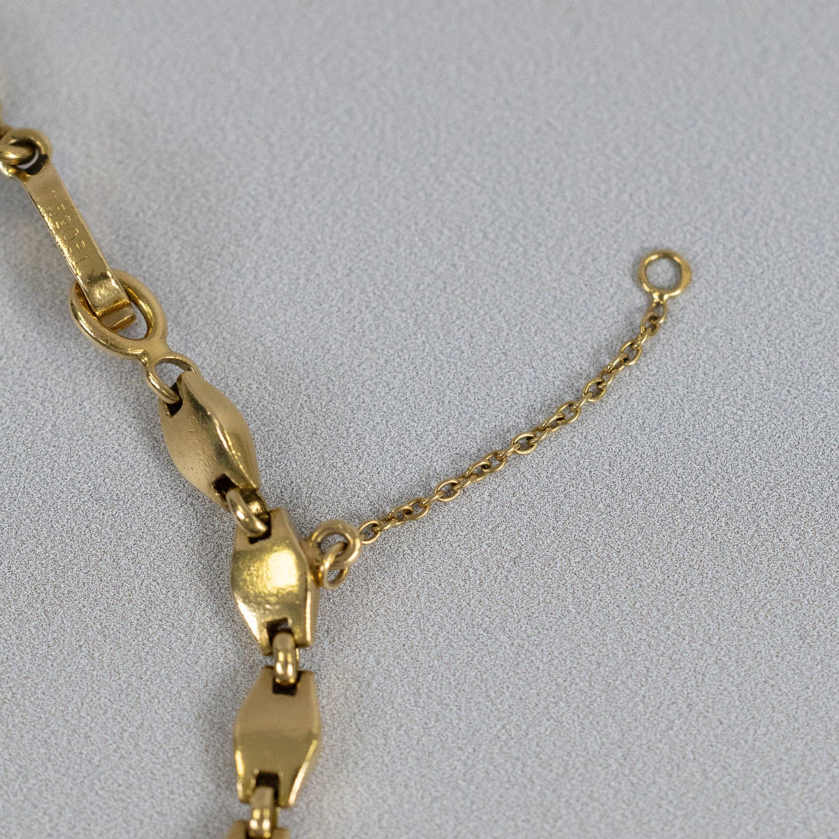 Attache godronnée en trois ors reliant le motif à la maille du collier Cartier