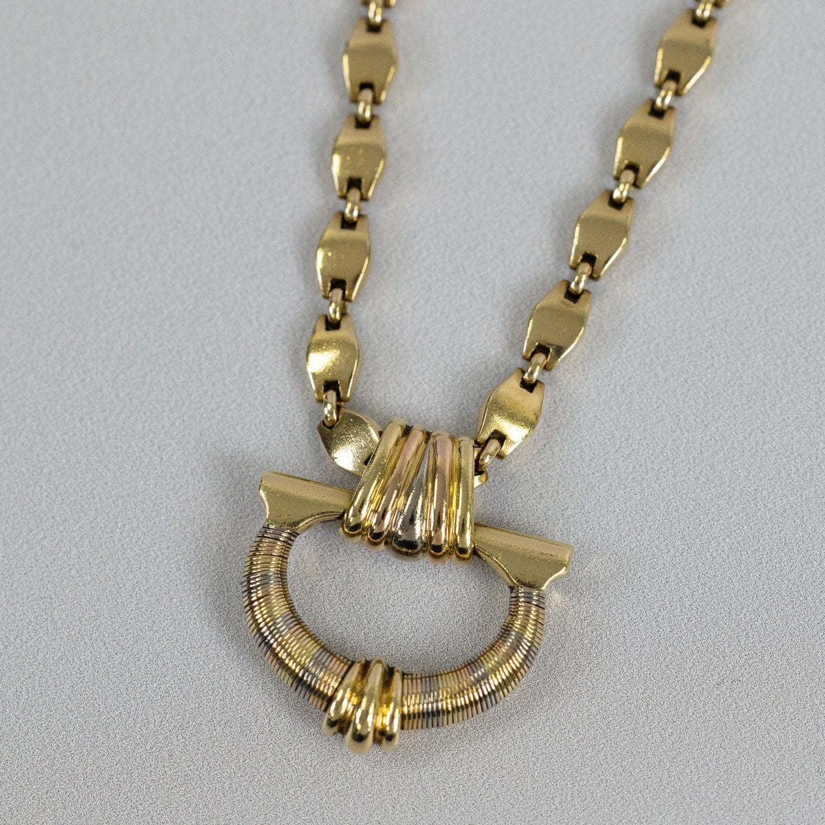 Motif ovale enroulé de fils d’or jaune, blanc et rose du collier Cartier