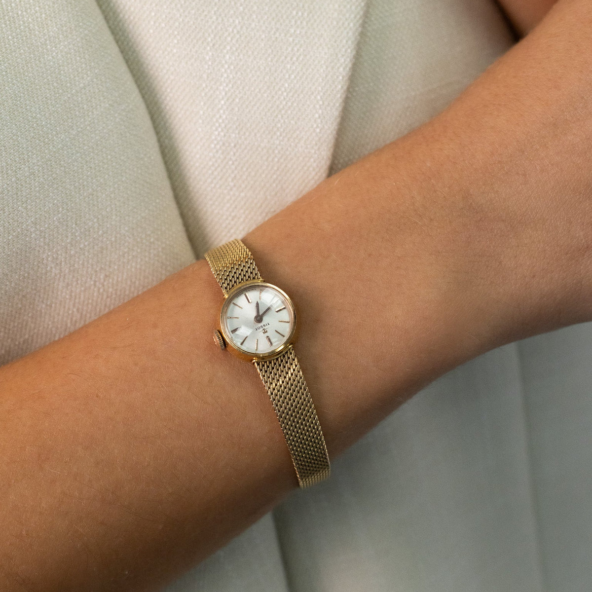 Montre de dame Tissot vintage en or jaune et diamants portée au poignet
