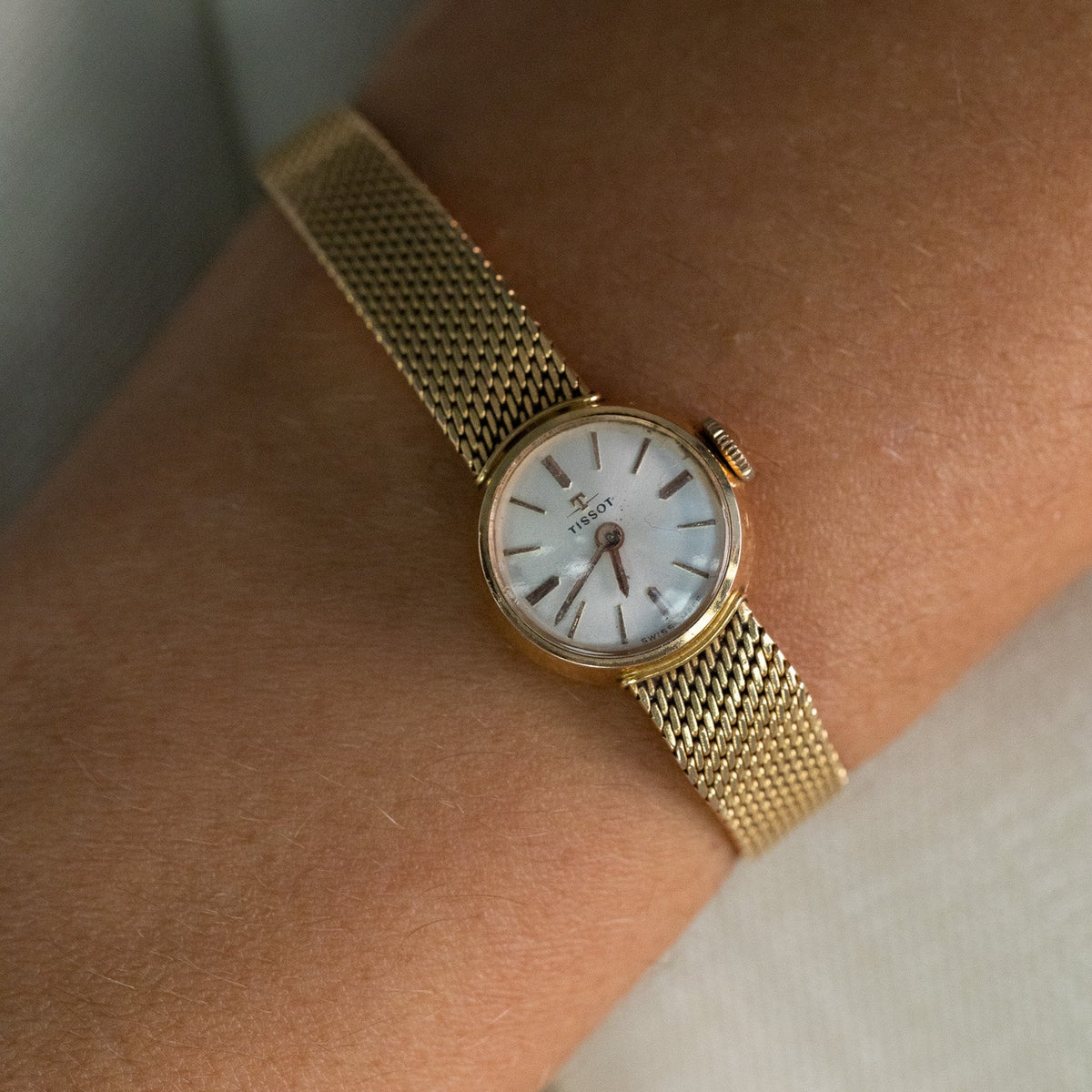 Montre de dame Tissot vintage en or jaune et diamants portée au poignet
