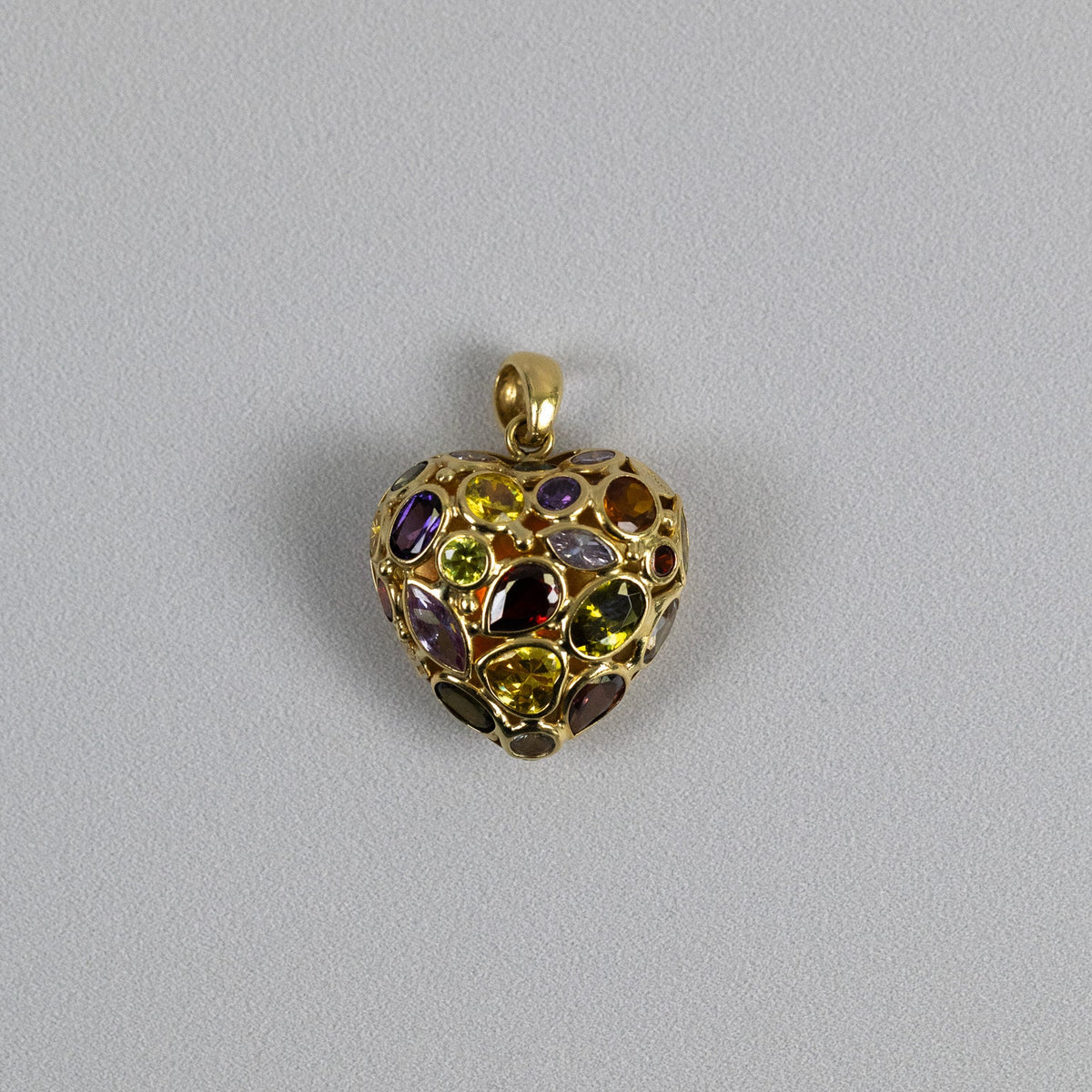 Pendentif cœur vintage en or jaune 18 carats serti de pierres multicolores sur fond gris