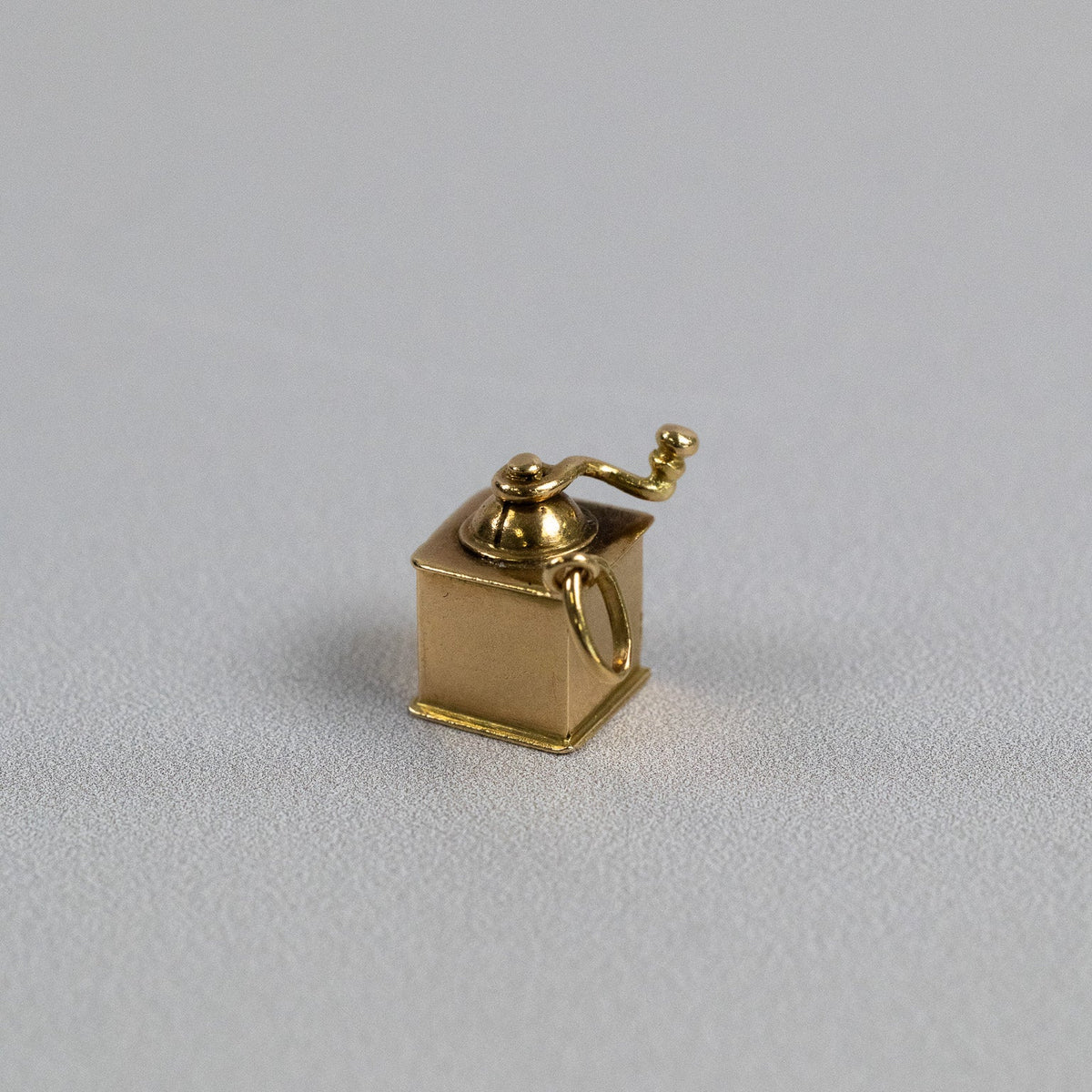 Détail de la manivelle et du dôme du pendentif moulin à café en or jaune