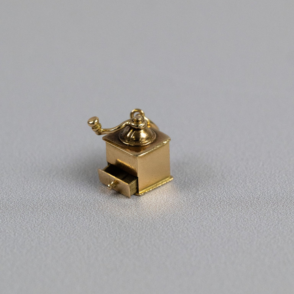 Pendentif moulin à café en or jaune porté sur une chaîne