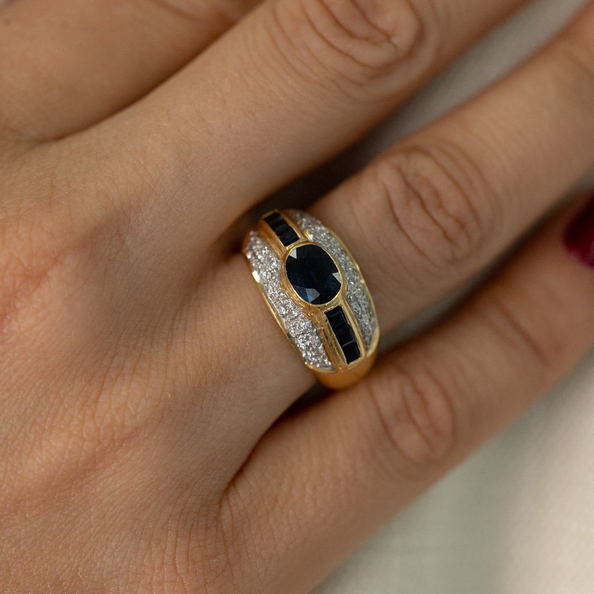 Gros plan bague jonc saphir ovale et double pavage de diamants portée