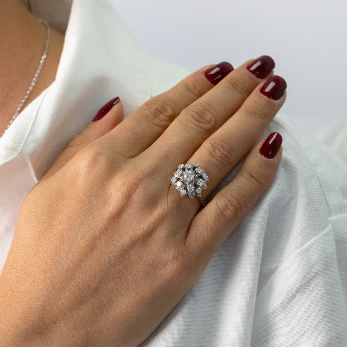 Bague fleur or blanc et diamants portée à la main