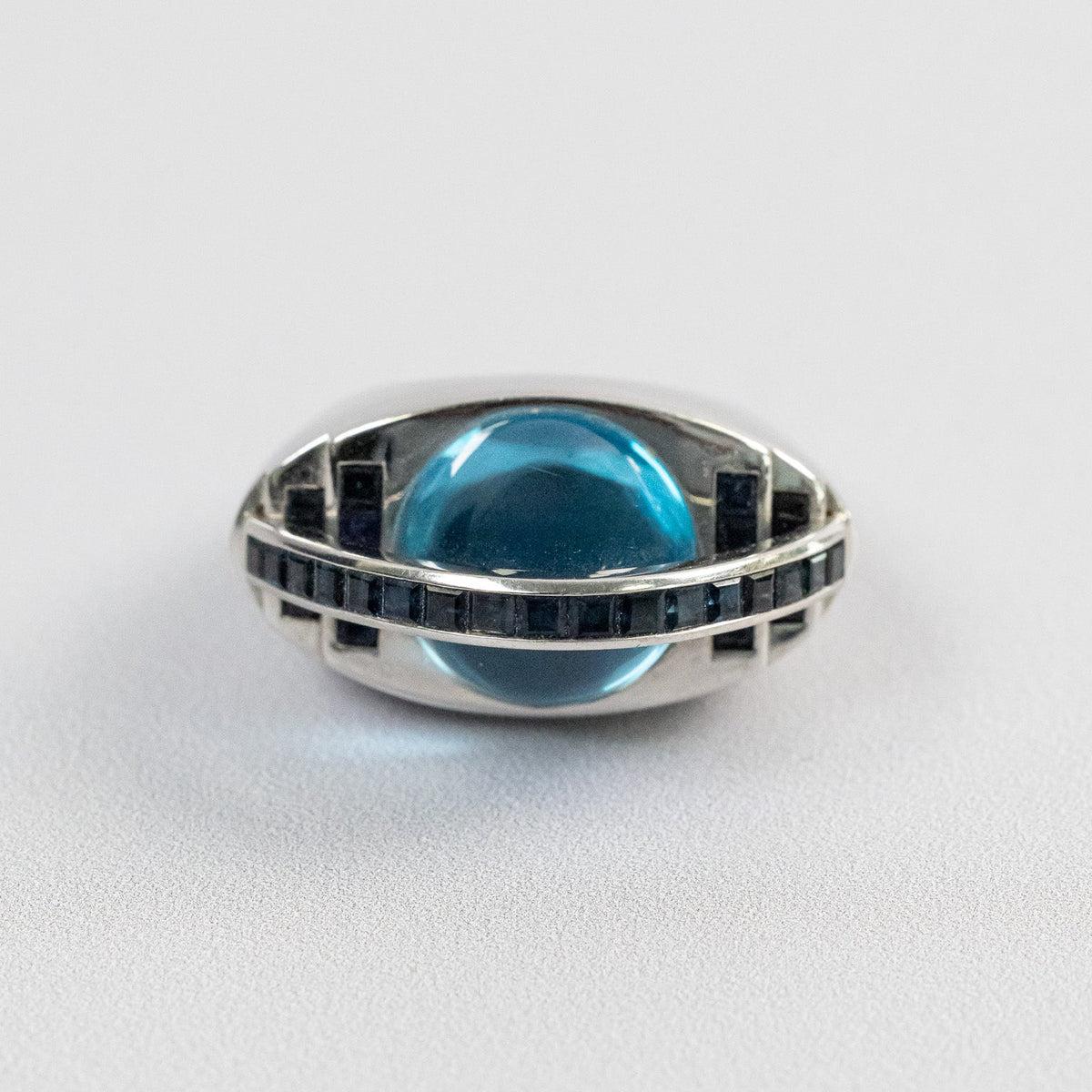 Bague forme œil en or blanc 18 carats, topaze bleue cabochon et saphirs baguettes, vue de face