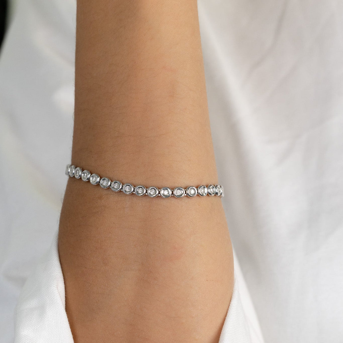 Ligne de diamants sertis clos du bracelet tennis en or blanc