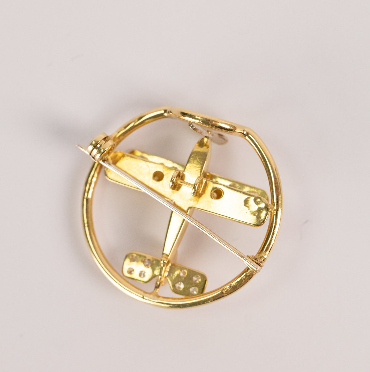 Biplan pavé de diamants suspendu dans un cercle d'or jaune