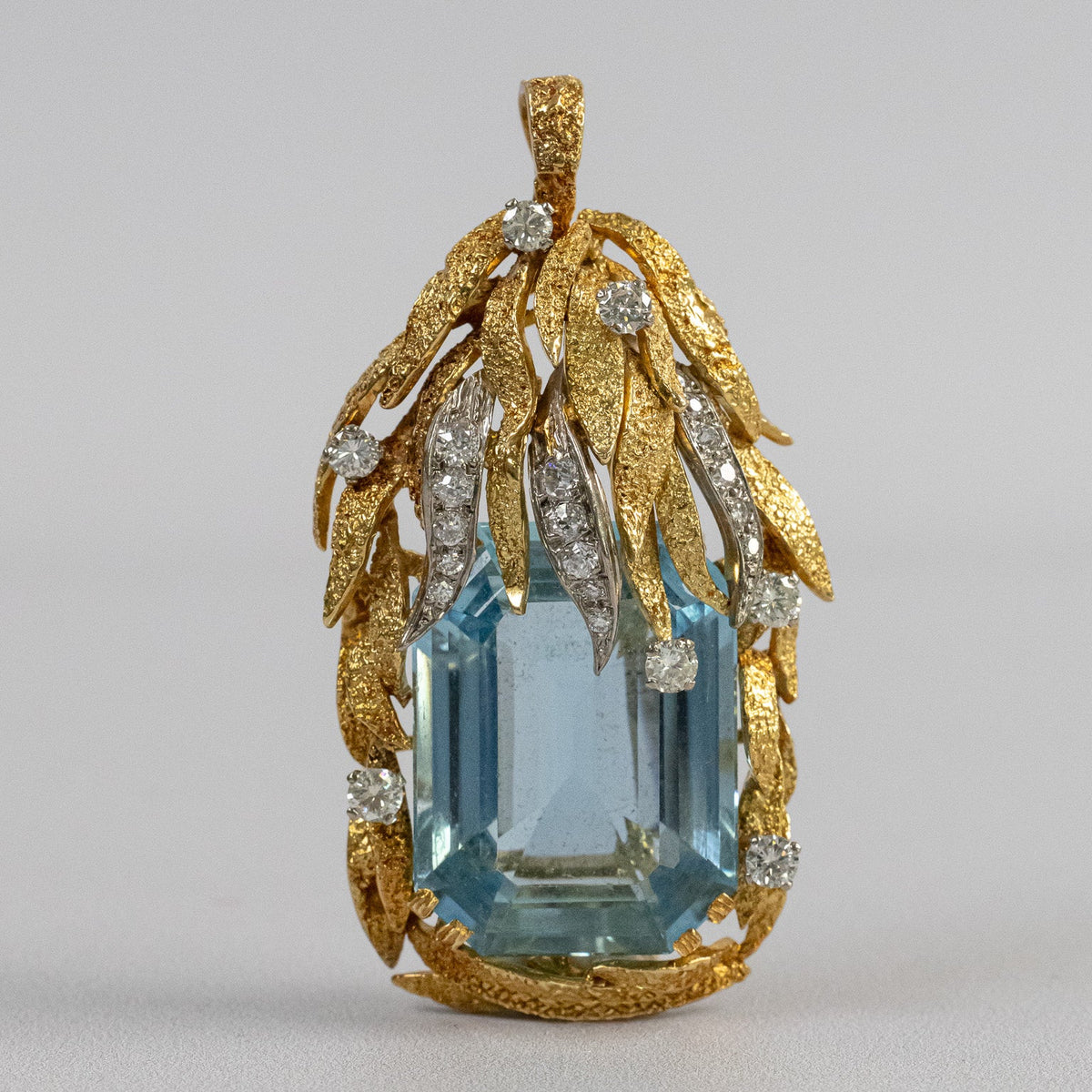 Détail des feuilles d’or jaune texturé et des diamants sertis sur or blanc